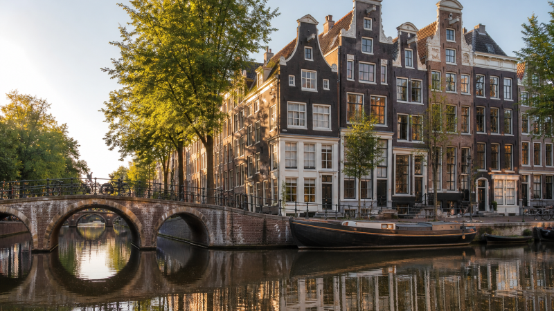 Historic Amsterdam canal houses and bridge in morning light